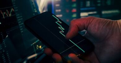 Trader analyzing stock market data on smartphone and phone