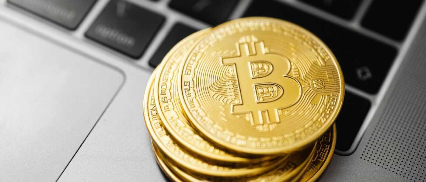 Gold bitcoins stacked on a laptop keyboard symbolizing digital currency and blockchain technology.