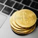 Gold bitcoins stacked on a laptop keyboard symbolizing digital currency and blockchain technology.