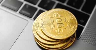 Gold bitcoins stacked on a laptop keyboard symbolizing digital currency and blockchain technology.