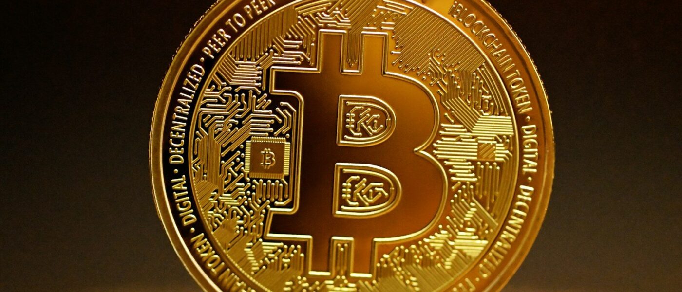 a golden bitcoin sitting on top of a table