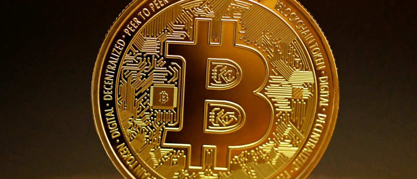 a golden bitcoin sitting on top of a table