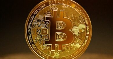 a golden bitcoin sitting on top of a table
