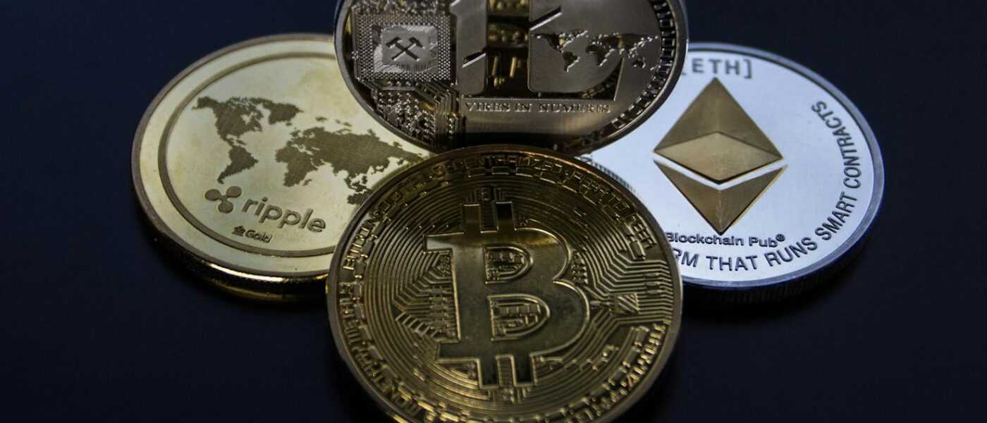 Detailed photo showcasing bitcoin, ethereum, litecoin, and ripple coins representing digital currency.