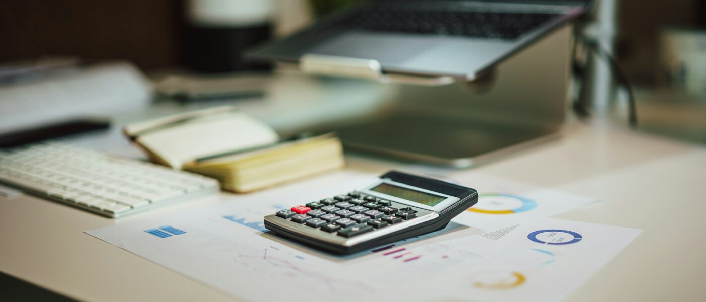 a calculator sitting on top of a table next to a laptop