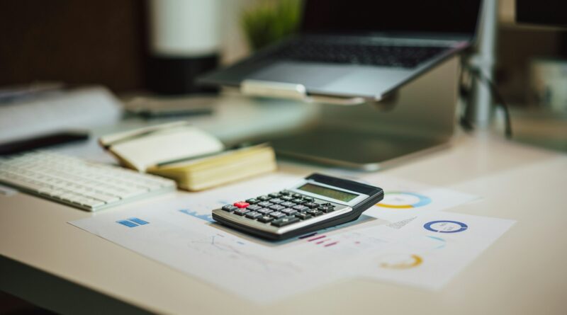 a calculator sitting on top of a table next to a laptop