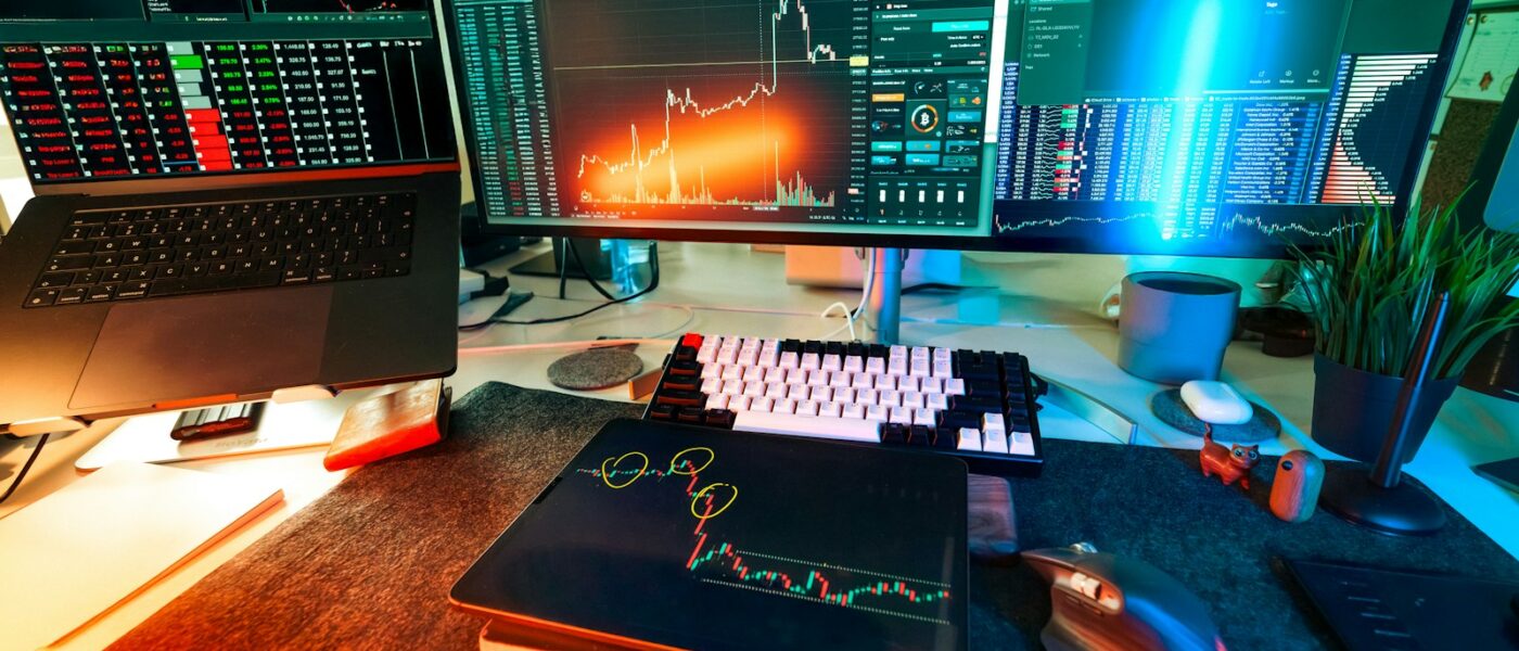 A trader's desk is lit up with charts.