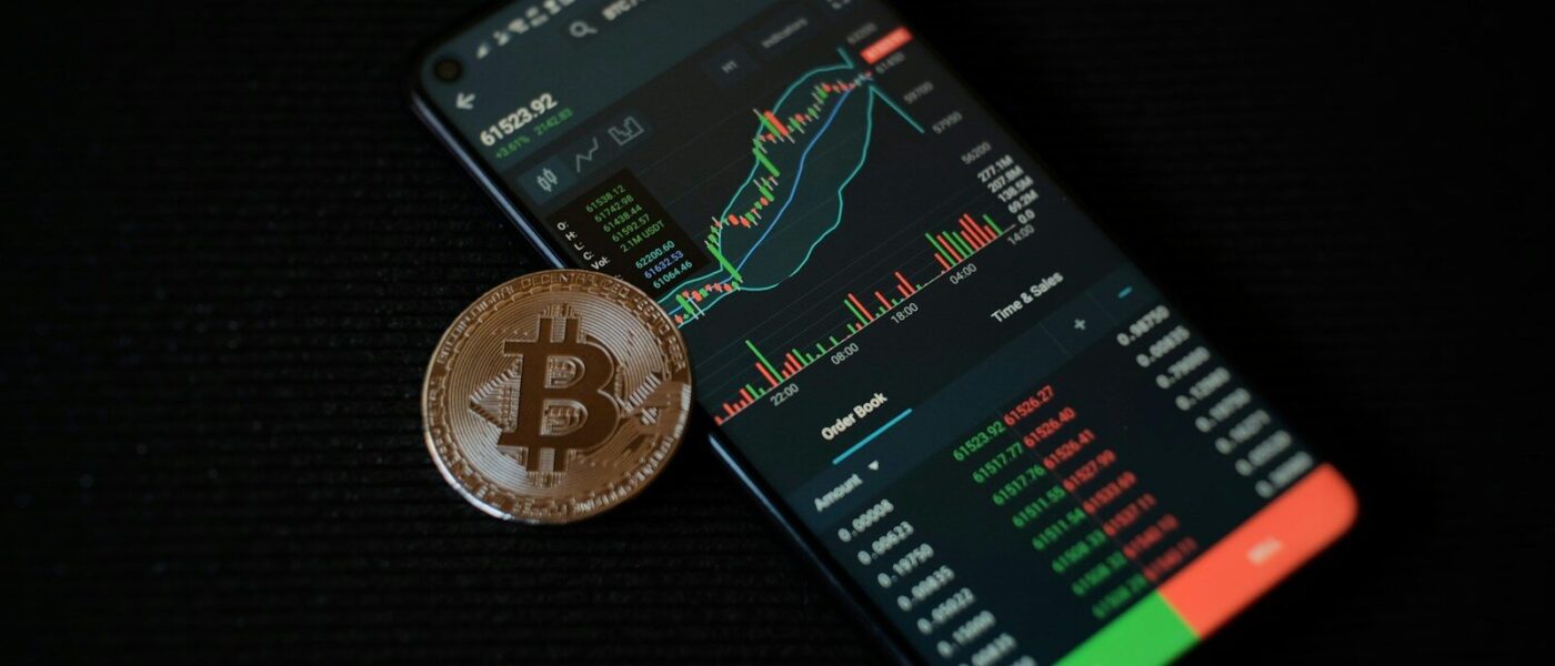 a bitcoin sitting on top of a smart phone