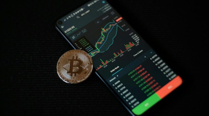a bitcoin sitting on top of a smart phone