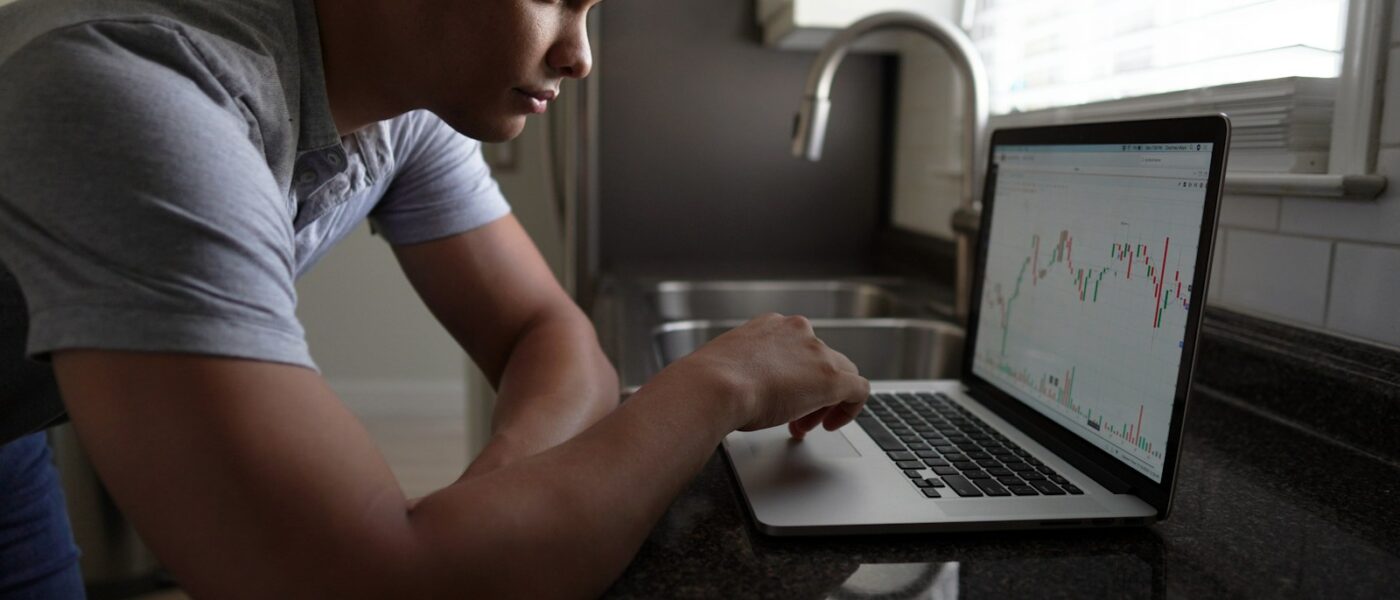 man in gray t-shirt using macbook pro