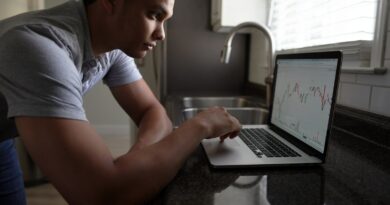 man in gray t-shirt using macbook pro