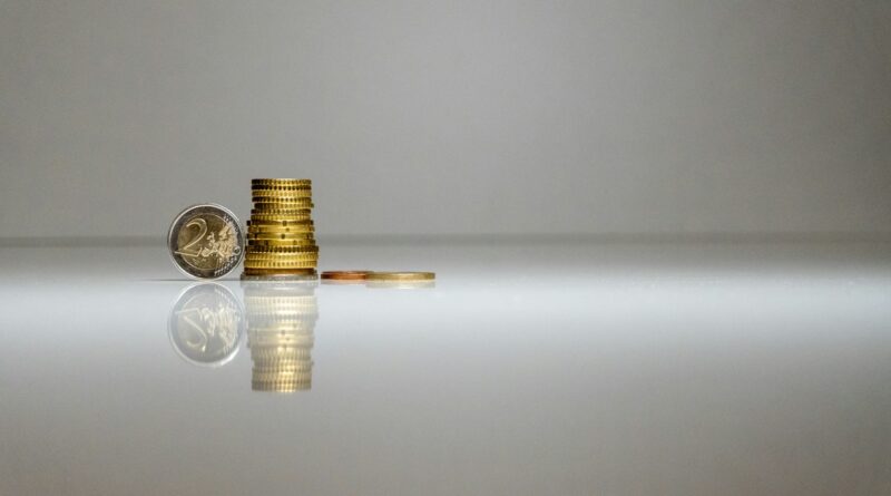 a stack of coins sitting on top of a reflective surface