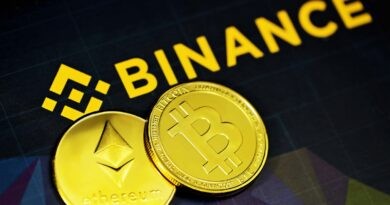 two gold bitcoins sitting next to a binance sign