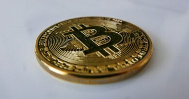 a gold bit coin sitting on top of a white table