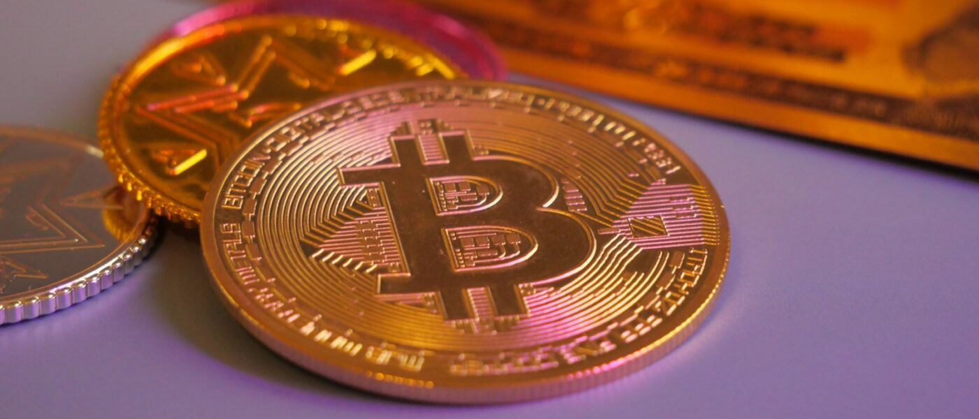 Golden bitcoin coin with other coins and card.