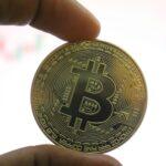 a person holding a bit coin in their hand