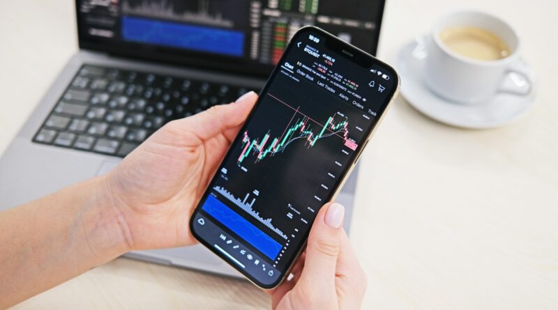 a person holding a cell phone in front of a laptop