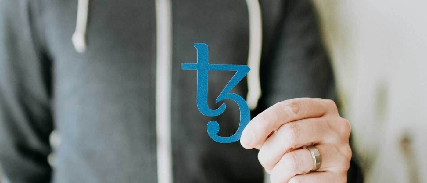a man in a black hoodie is holding a blue sticker