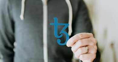 a man in a black hoodie is holding a blue sticker