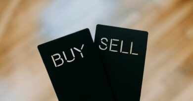 a hand holding two black cards with the words buy and sell written on them